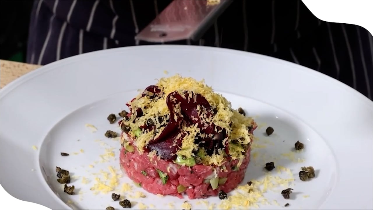 Köksmästaren lagar råbiff med gravade äggulor