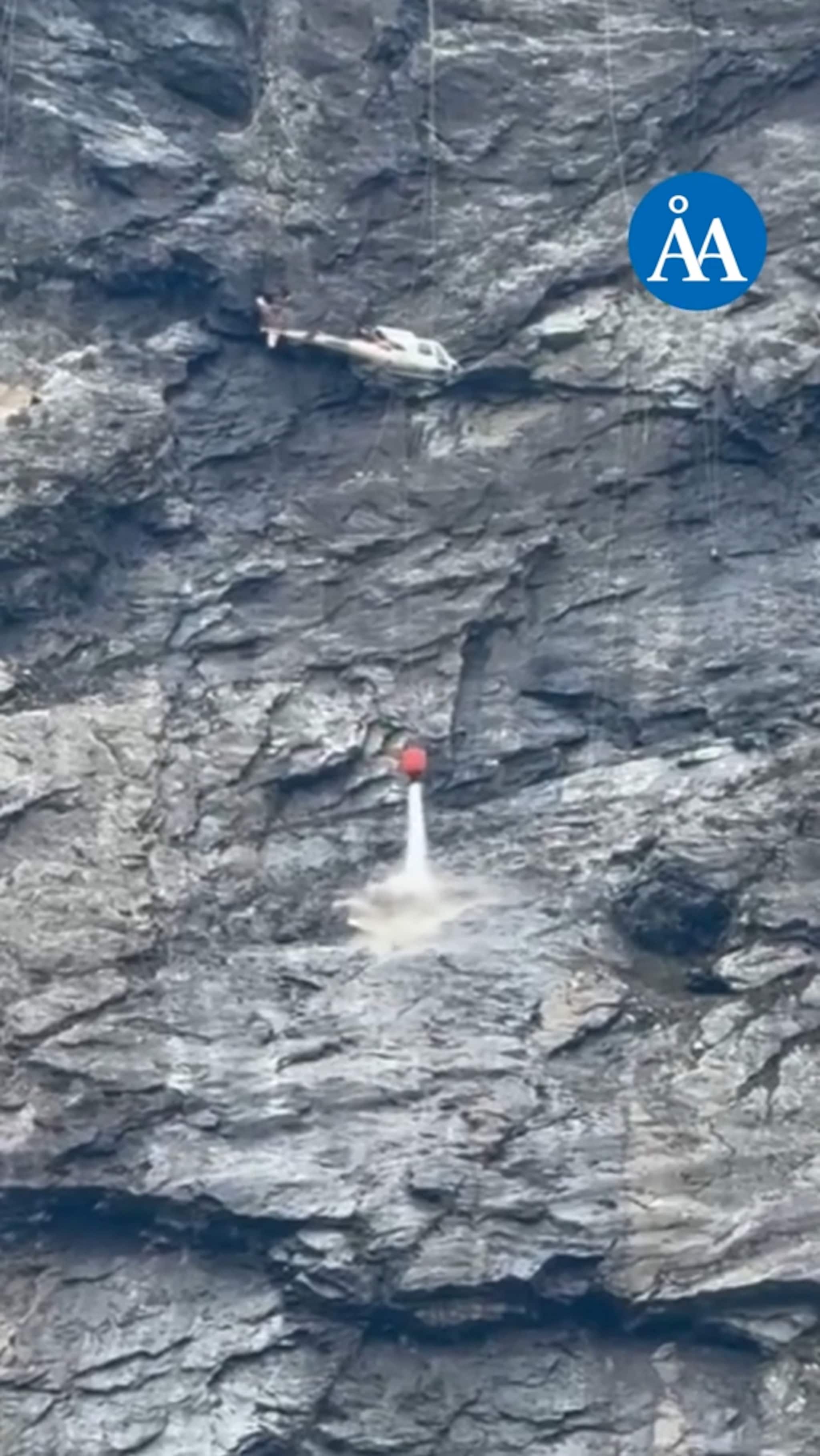 Spyler fjellsiden med helikopter