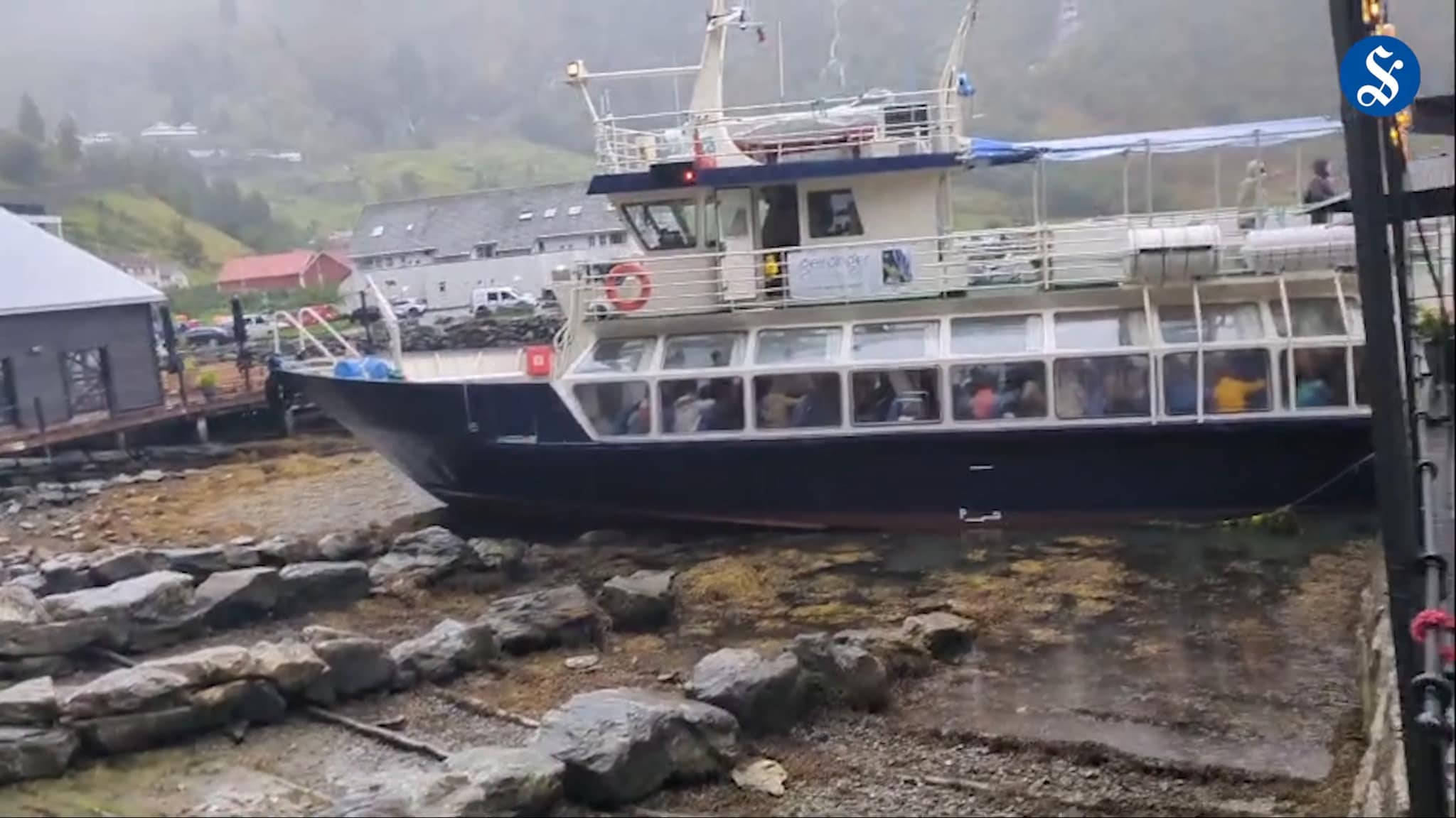 Båten Geirangerfjord i fjøresteinene i Geiranger